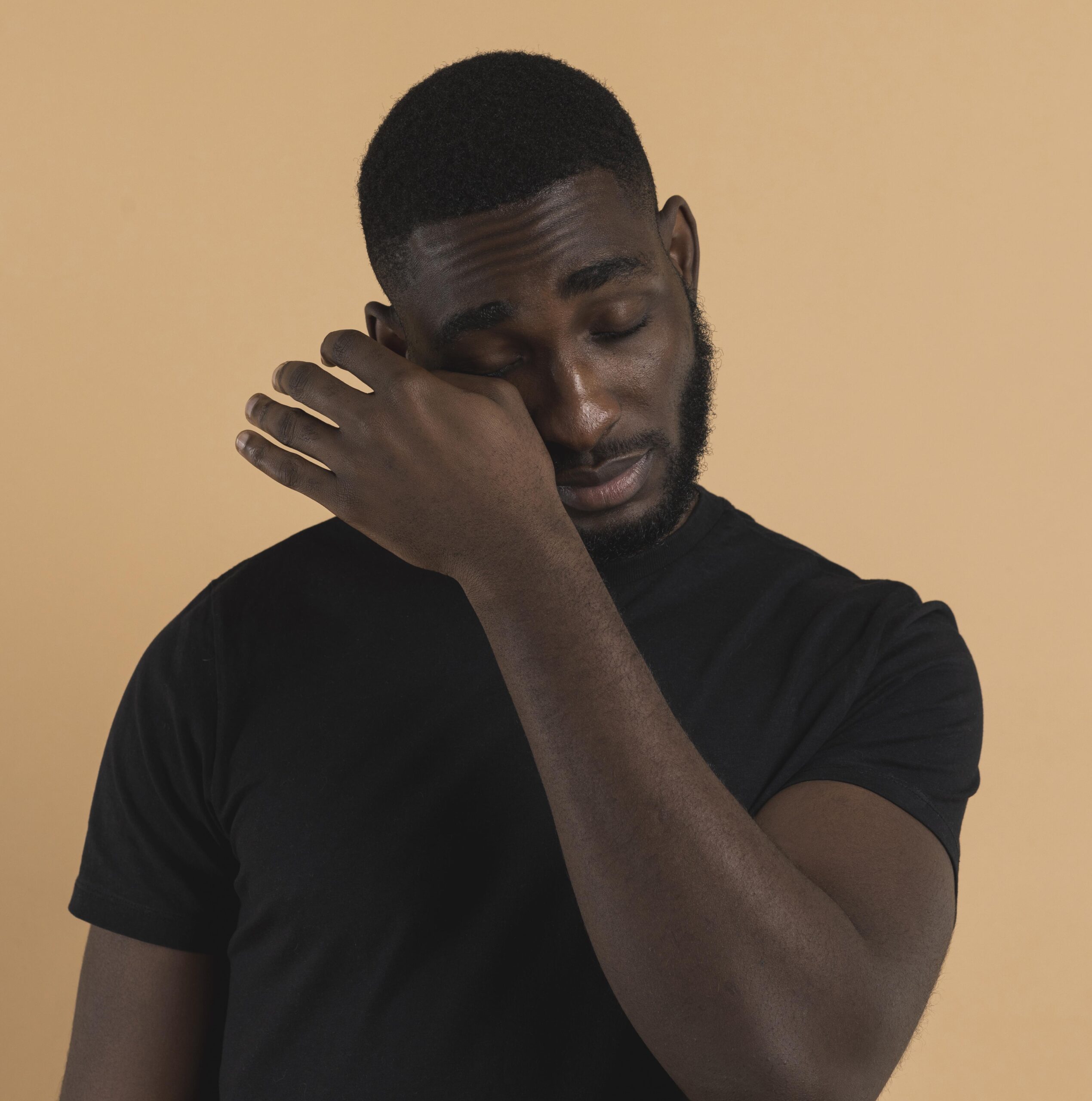 homme qui essuie une larme en raison du coût de la vie