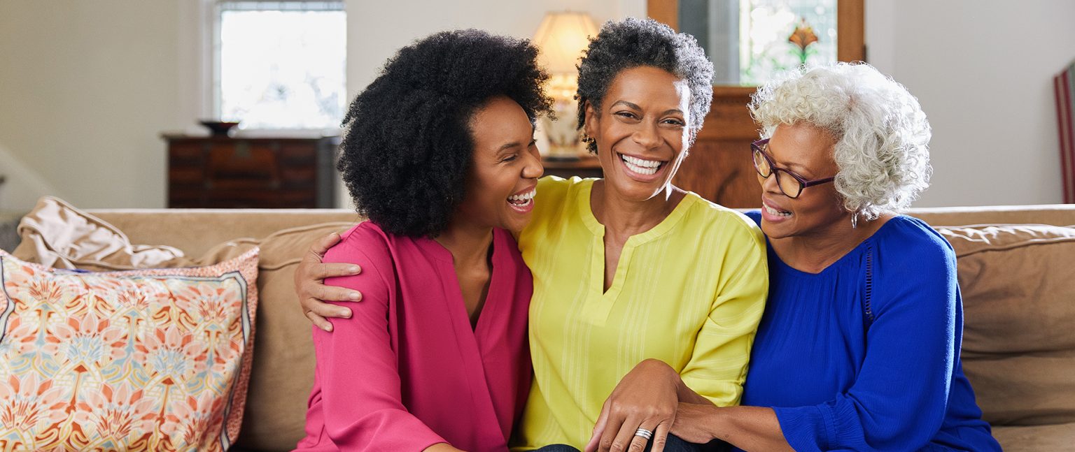 Trois générations de femmes antillaises souriantes, symbole de la mutuelle seniors Martinique avec garanties décès et dépendance